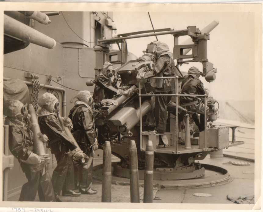 british_navy_six_man_gun_crew_wear_gas_mask_to_load_4.5_inch_aa_gun.jpg